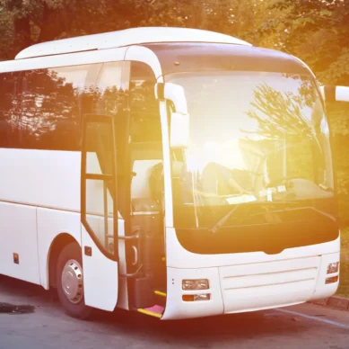 White tourist bus for excursions. The bus is parked in a parking lot near the park